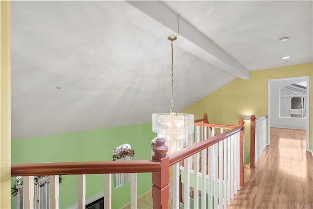 hallway with baseboards, a chandelier, lofted ceiling with beams, an upstairs landing, and wood finished floors