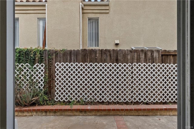 view of side of property featuring fence and stucco siding