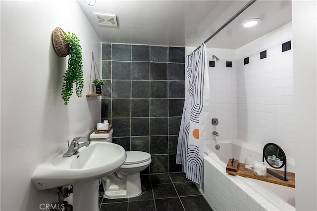 bathroom with tile patterned flooring, visible vents, toilet, and tiled shower / bath