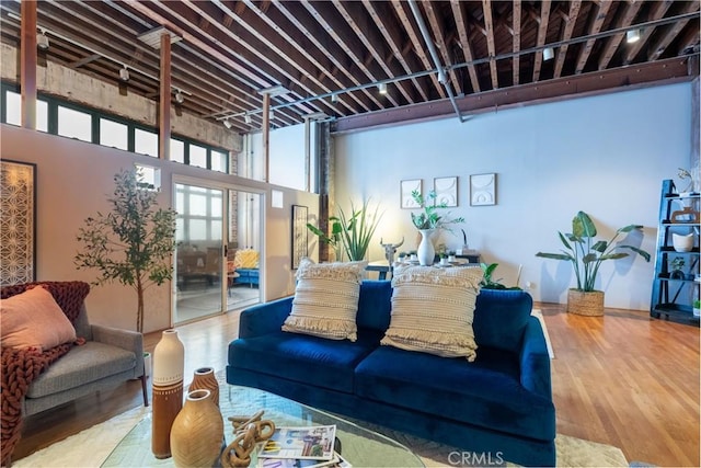 living area featuring wood finished floors and a towering ceiling