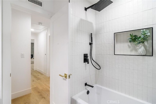 full bath featuring visible vents, shower / washtub combination, baseboards, and wood finished floors