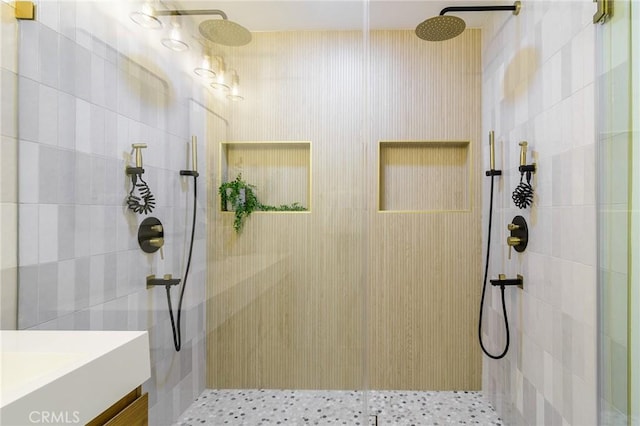 bathroom featuring vanity and tiled shower