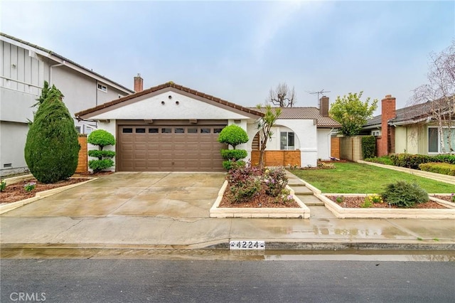 view of front of home with a front lawn, a tile roof, concrete driveway, a chimney, and a garage