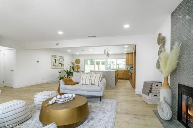 living area featuring recessed lighting, visible vents, light wood-style floors, and a fireplace