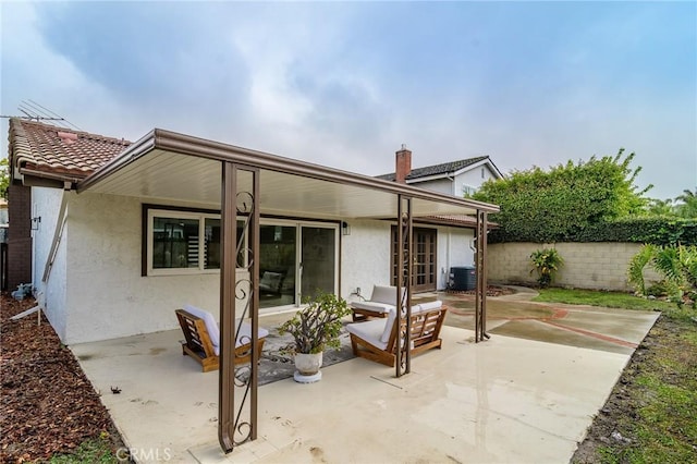 rear view of property featuring central AC unit, stucco siding, a patio, and fence