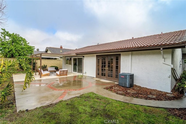 back of property featuring a patio, a tiled roof, stucco siding, outdoor lounge area, and central air condition unit