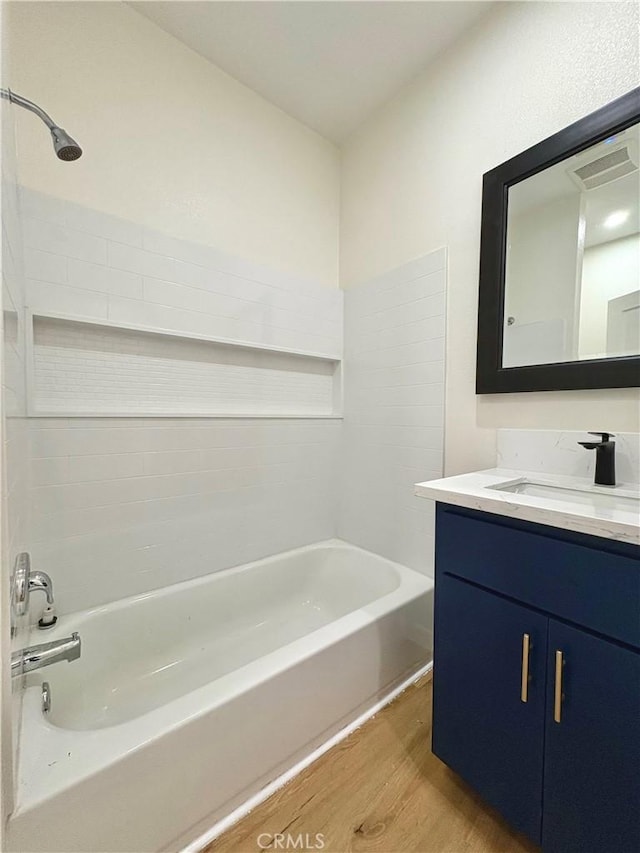 full bath featuring tub / shower combination, visible vents, wood finished floors, and vanity