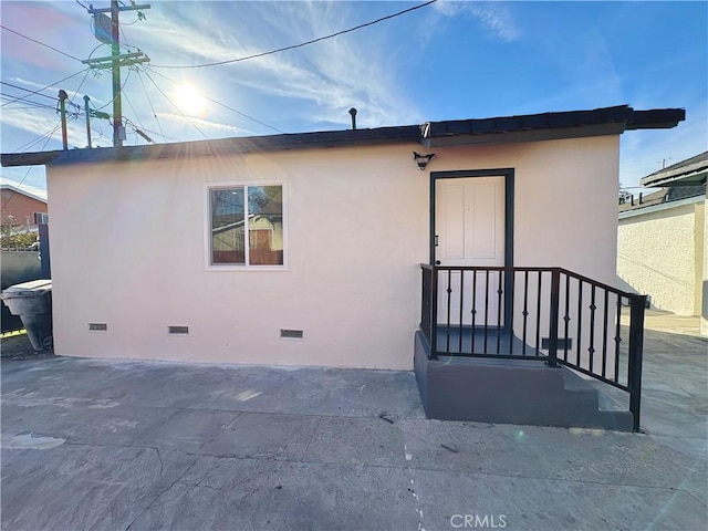 back of house featuring a patio, stucco siding, and crawl space