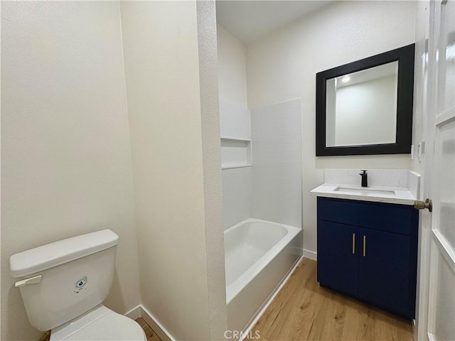 bathroom featuring vanity, toilet, wood finished floors, and baseboards