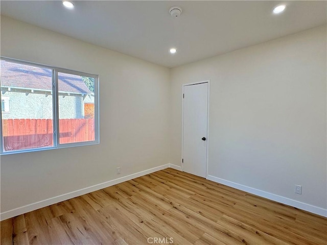 spare room featuring recessed lighting, baseboards, and light wood finished floors