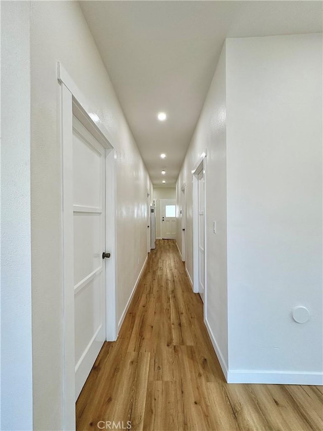 hallway featuring recessed lighting, wood finished floors, and baseboards