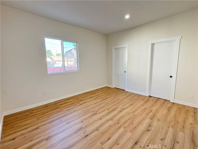 unfurnished bedroom featuring recessed lighting, light wood-style flooring, and baseboards