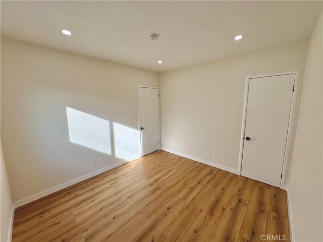 spare room featuring recessed lighting, baseboards, and light wood-style floors