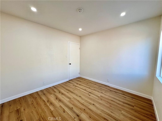 empty room featuring recessed lighting, light wood-style floors, and baseboards