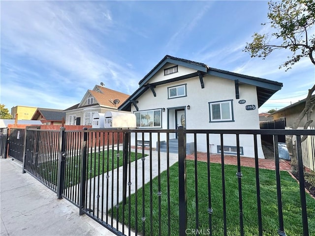 view of front of home featuring stucco siding, a front yard, and fence