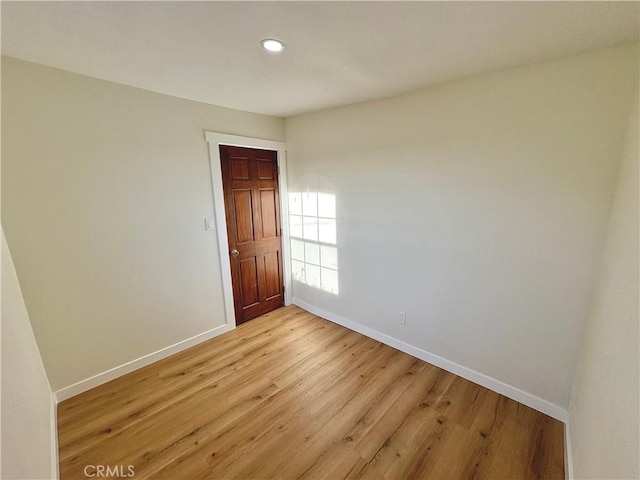 unfurnished room featuring light wood finished floors, recessed lighting, and baseboards