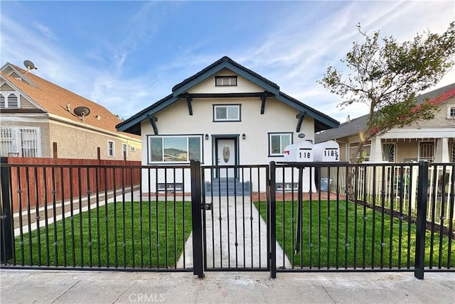 view of front facade featuring stucco siding, a fenced front yard, a front lawn, and a gate