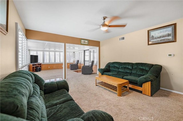 living area with visible vents, baseboards, a ceiling fan, and carpet floors