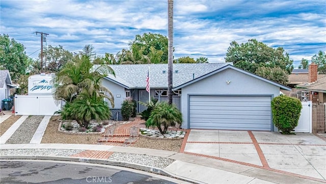 view of front of home with a gate, stucco siding, concrete driveway, and fence