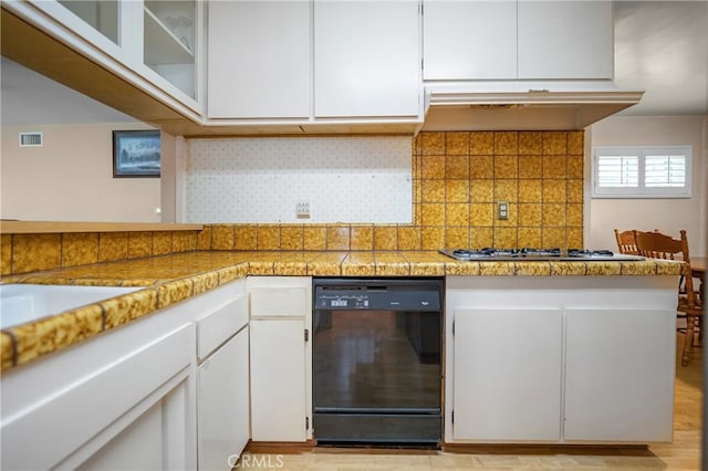 kitchen with dishwasher, white cabinets, gas stovetop, and visible vents