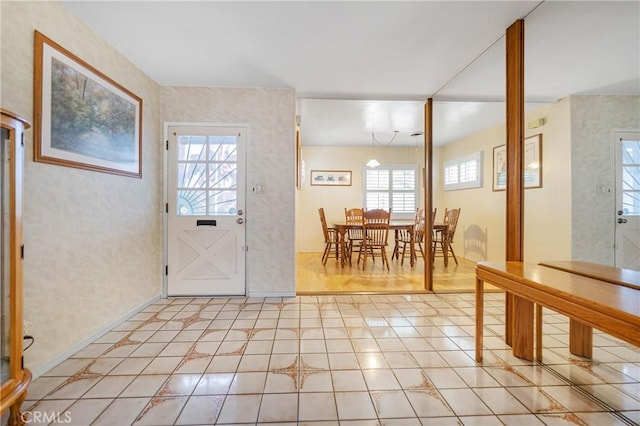 entrance foyer with light tile patterned floors and a healthy amount of sunlight