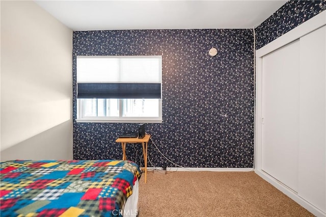 bedroom with baseboards, carpet floors, a closet, and wallpapered walls