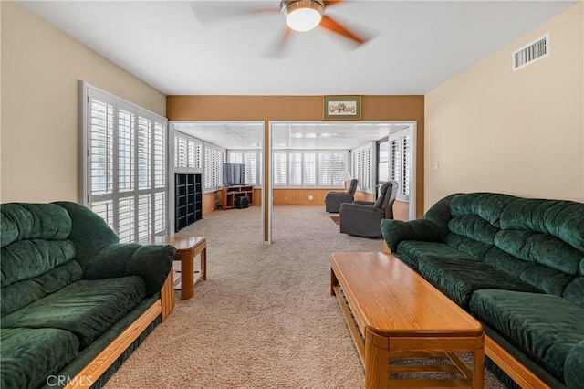 living room featuring visible vents, carpet floors, and ceiling fan