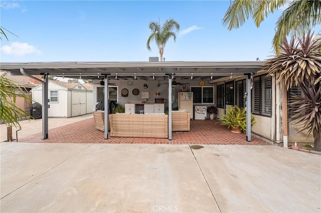 rear view of house with an outbuilding, a ceiling fan, a storage shed, outdoor lounge area, and a patio area