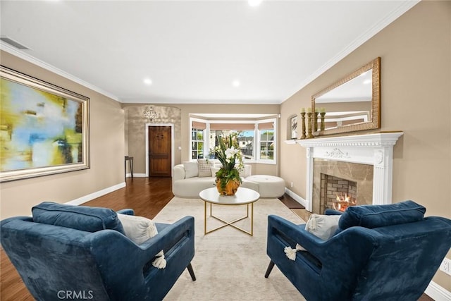 living area with visible vents, wood finished floors, a high end fireplace, and ornamental molding