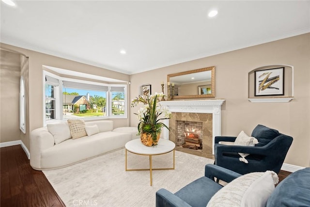 living room featuring baseboards, wood finished floors, and crown molding