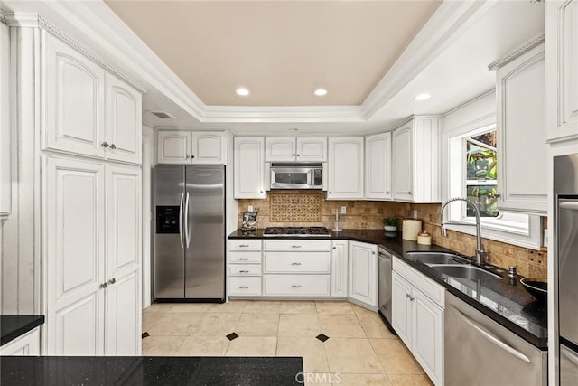 kitchen with backsplash, light tile patterned floors, appliances with stainless steel finishes, a raised ceiling, and a sink