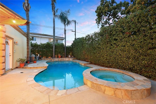 view of swimming pool with a patio area and a pool with connected hot tub