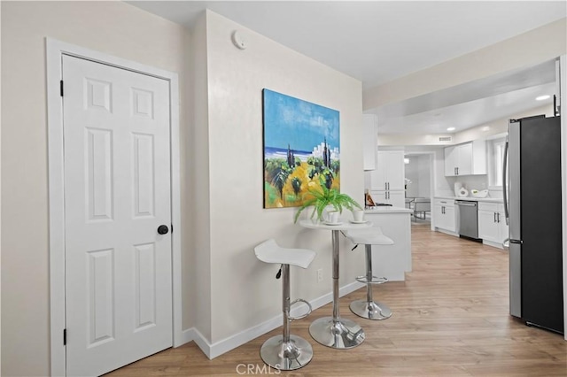 hallway with light wood finished floors and baseboards