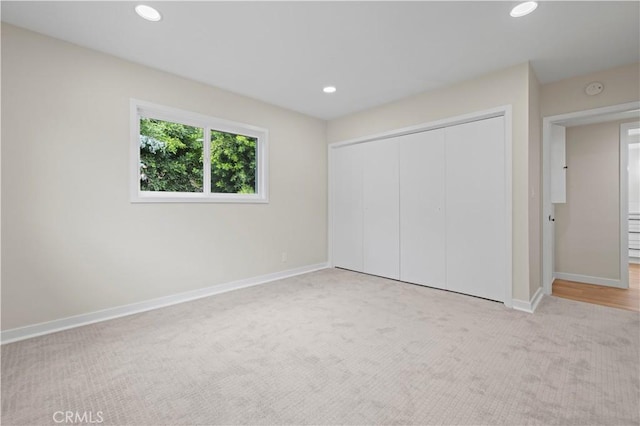 unfurnished bedroom featuring recessed lighting, a closet, baseboards, and carpet floors