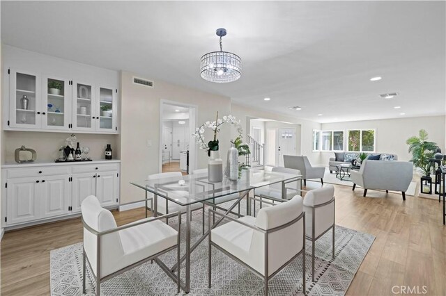 dining area with recessed lighting, visible vents, a notable chandelier, and light wood finished floors