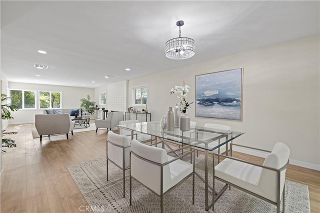 dining room featuring a wealth of natural light, visible vents, a notable chandelier, and light wood-style floors