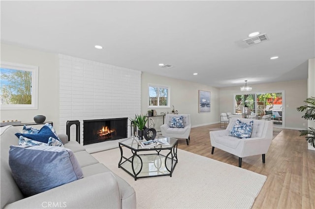 living room with light wood finished floors, visible vents, recessed lighting, and baseboards