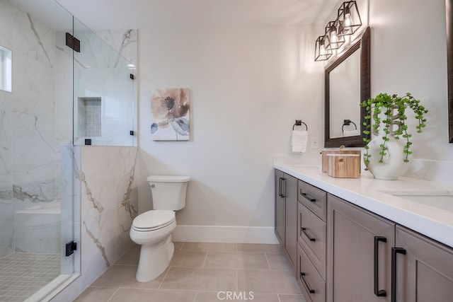 full bath featuring a marble finish shower, toilet, baseboards, and double vanity