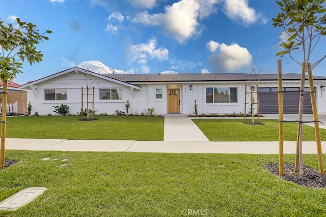 single story home featuring an attached garage, driveway, a front lawn, and board and batten siding