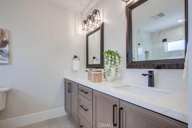 full bath featuring baseboards, visible vents, a marble finish shower, double vanity, and a sink