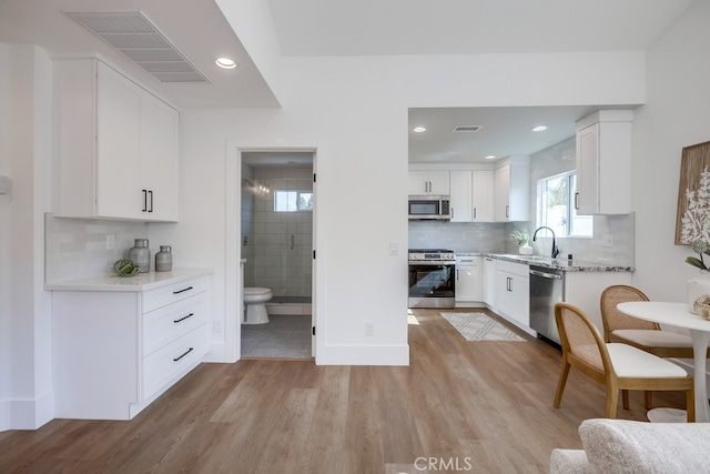 kitchen with light wood-style flooring, visible vents, appliances with stainless steel finishes, and a sink