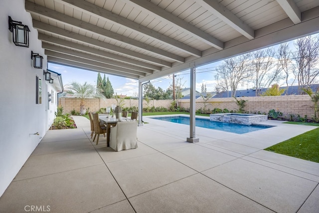 view of swimming pool with outdoor dining space, a pool with connected hot tub, a patio area, and a fenced backyard