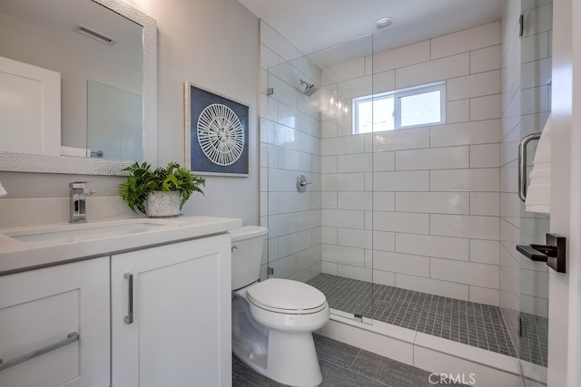 bathroom with vanity, toilet, visible vents, and a stall shower