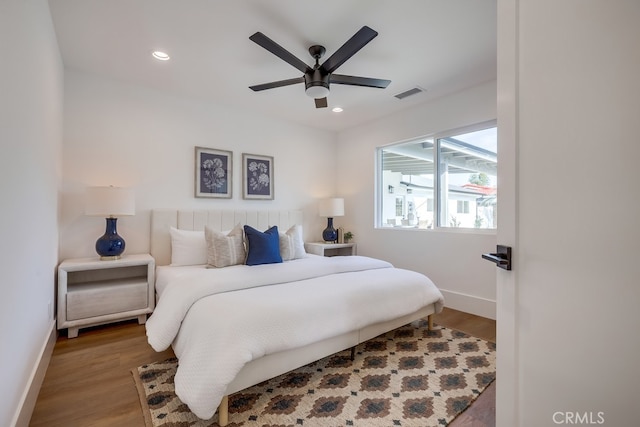 bedroom with visible vents, baseboards, and wood finished floors