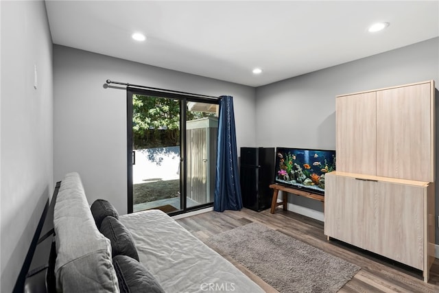 bedroom featuring recessed lighting, wood finished floors, and access to outside