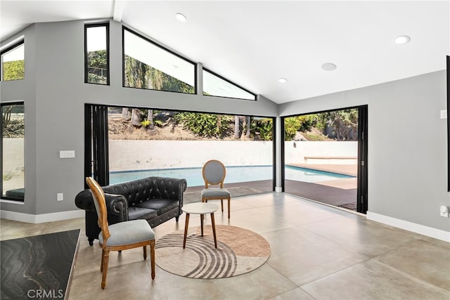 sitting room with recessed lighting, baseboards, high vaulted ceiling, and concrete floors