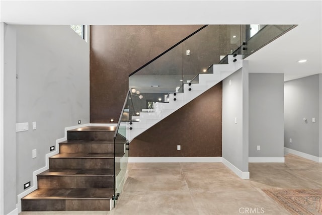 stairway with concrete floors and baseboards