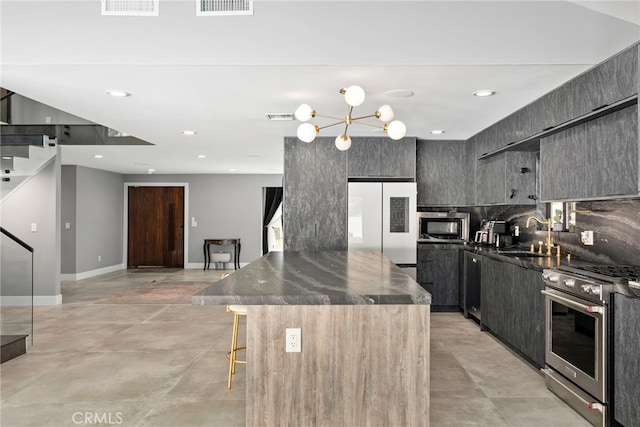 kitchen with visible vents, a center island, a kitchen bar, appliances with stainless steel finishes, and a sink