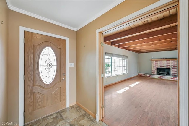 foyer entrance with beam ceiling, wood finished floors, a fireplace, crown molding, and baseboards