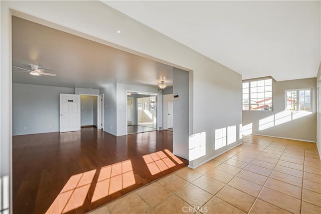 tiled empty room featuring ceiling fan